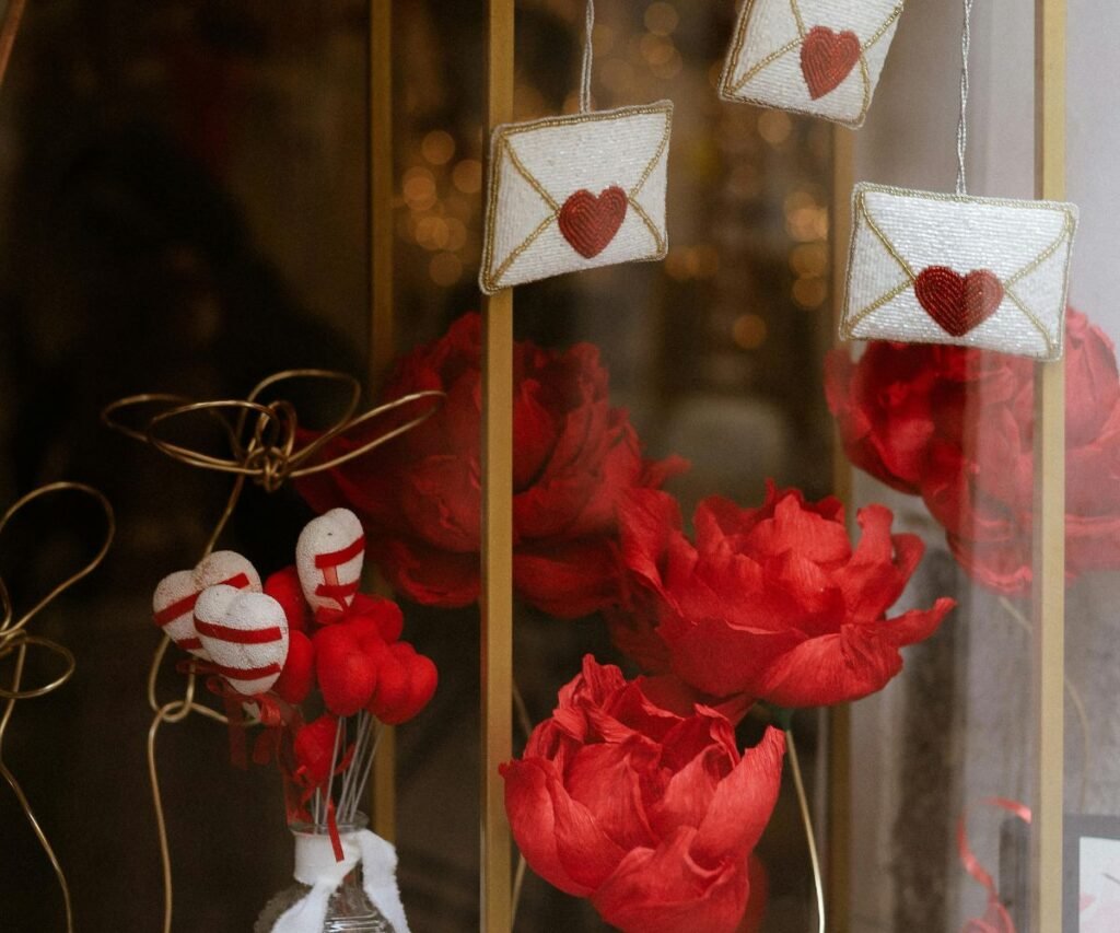 Valentine's Day window display with hanging love letter envelopes, red flowers, and romantic decorations